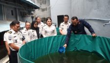 Foto : Kepala Rutan (Karutan) Kelas I Labuhan Deli, Eksa Rahnuzulian, melakukan penebaran benih ikan nila dan mujair. (Ist)
